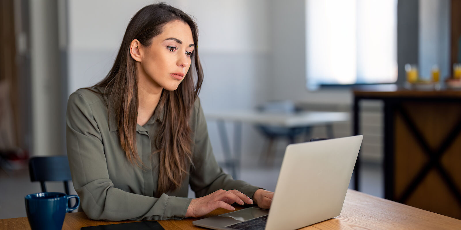 Eine Frau informiert sich an einem Laptop auf der Website der Maintal Werke